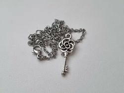 Silverfärgat halsband med en nyckel