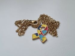 Guldfärgat halsband med en pusselbit / medvetenhet