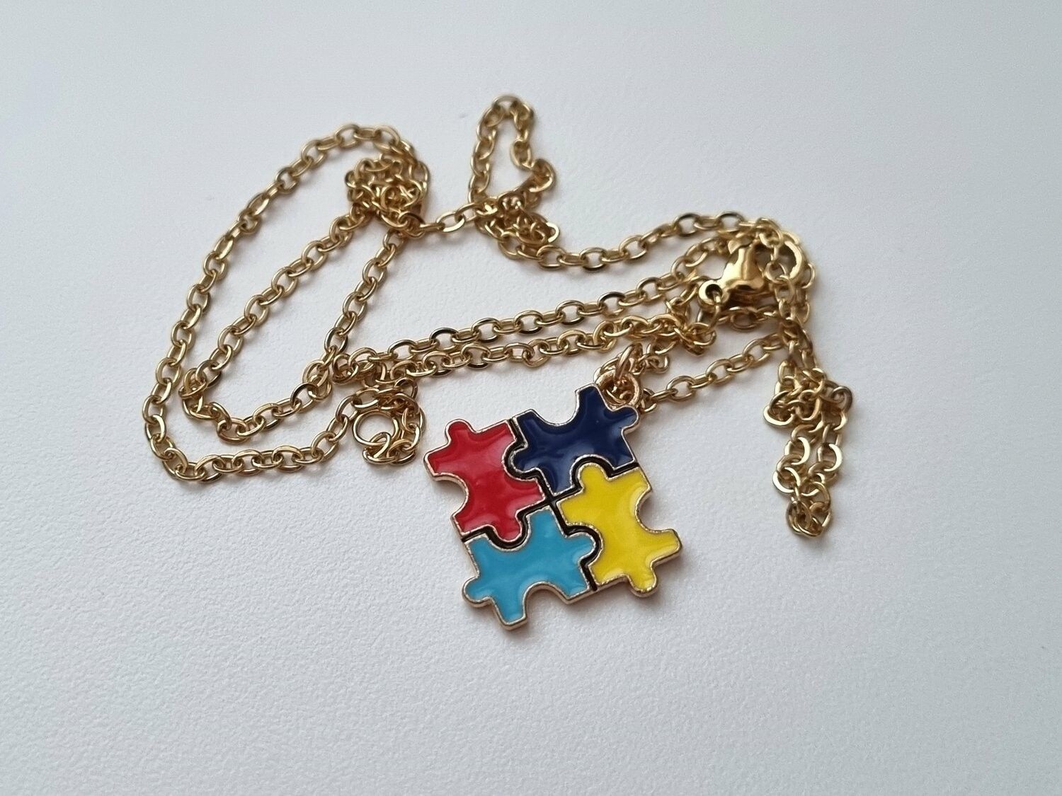 Guldfärgat halsband med en pusselbit / medvetenhet