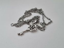 Silverfärgat halsband med en nyckel