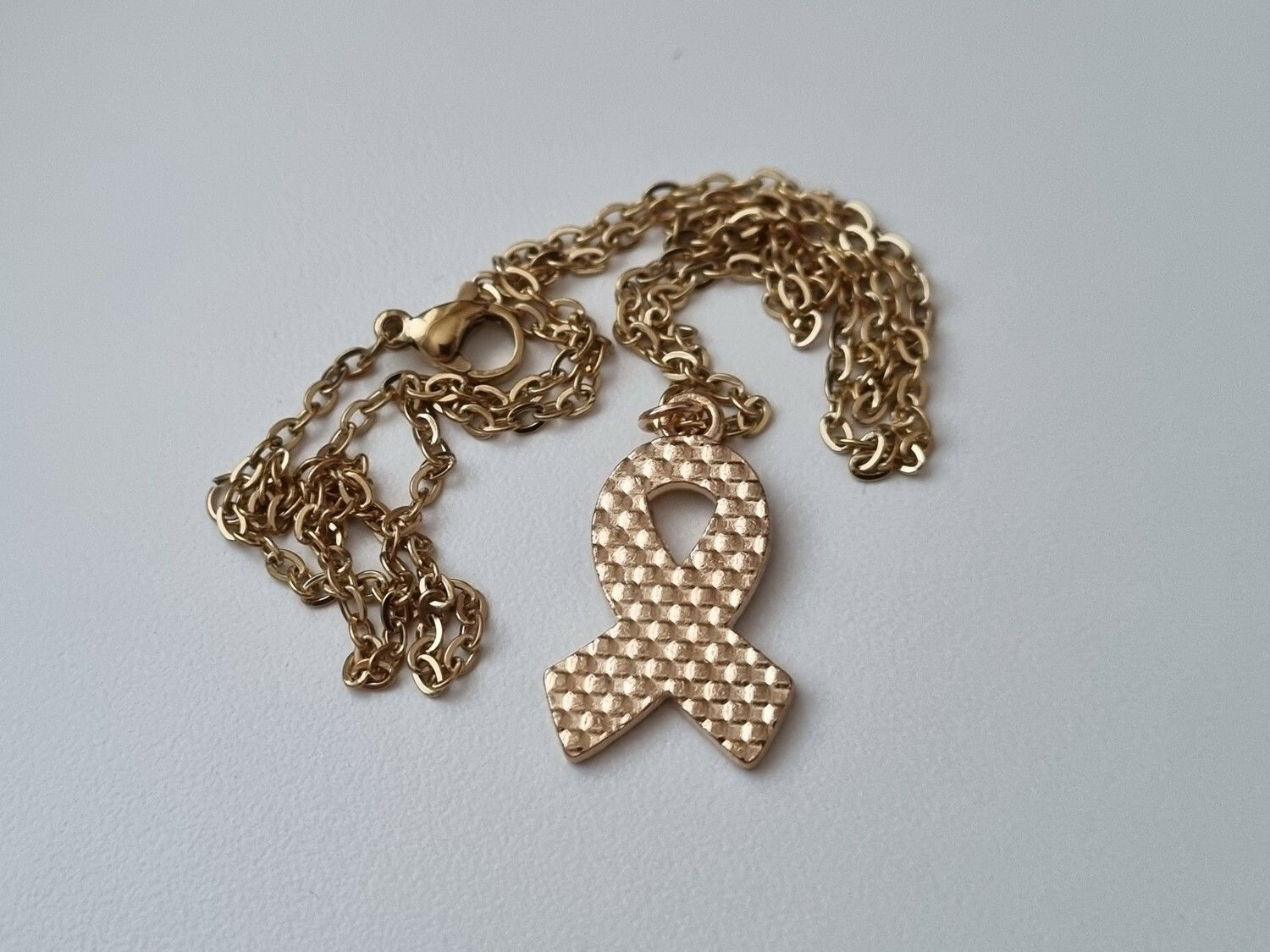 Guldfärgat halsband med en pusselbit / medvetenhet