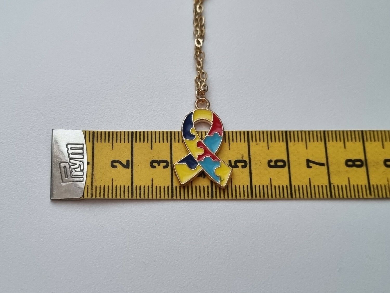 Guldfärgat halsband med en pusselbit / medvetenhet