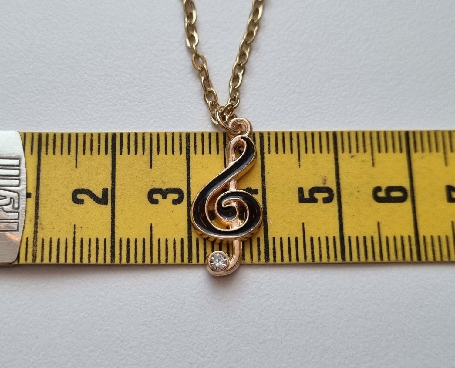 Guldfärgat halsband med en svart musiknot