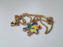 Guldfärgat halsband med en pusselbit / medvetenhet