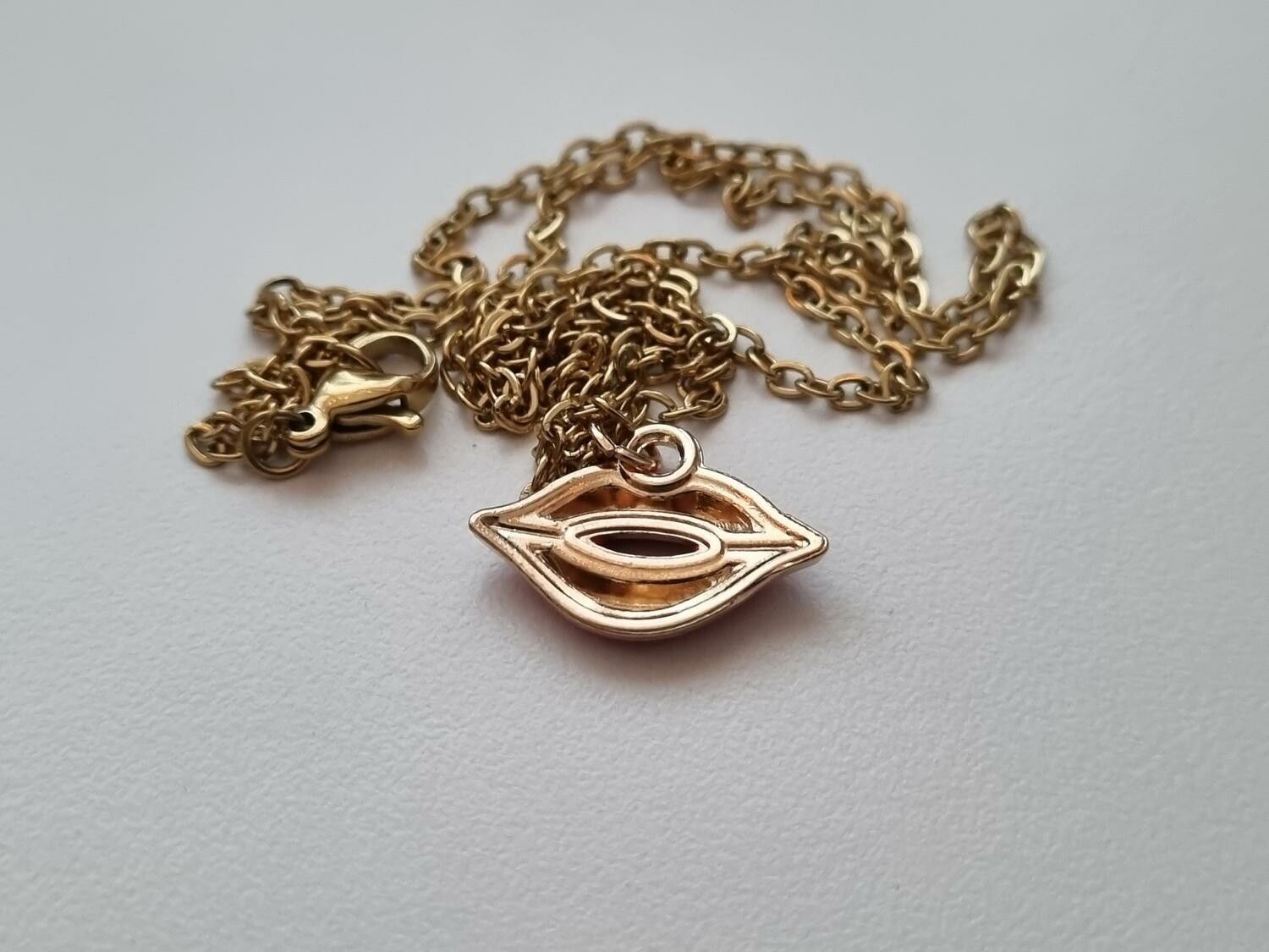 Guldfärgat halsband med en mun / munberlock