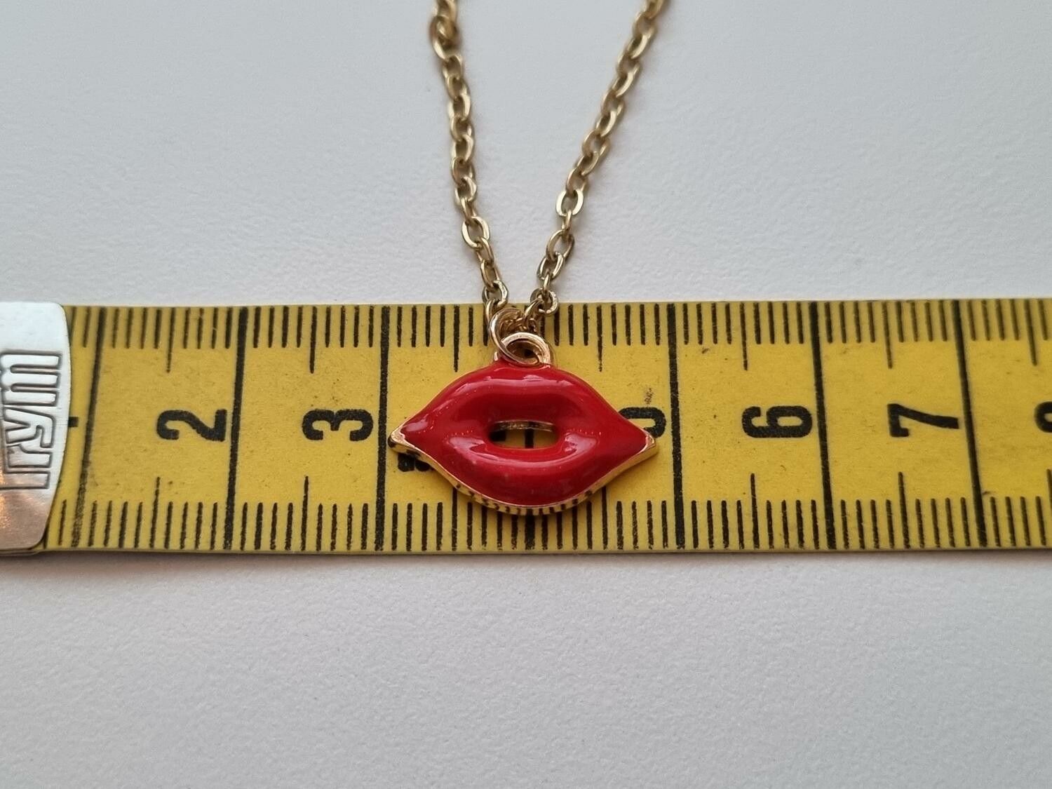 Guldfärgat halsband med en mun / munberlock
