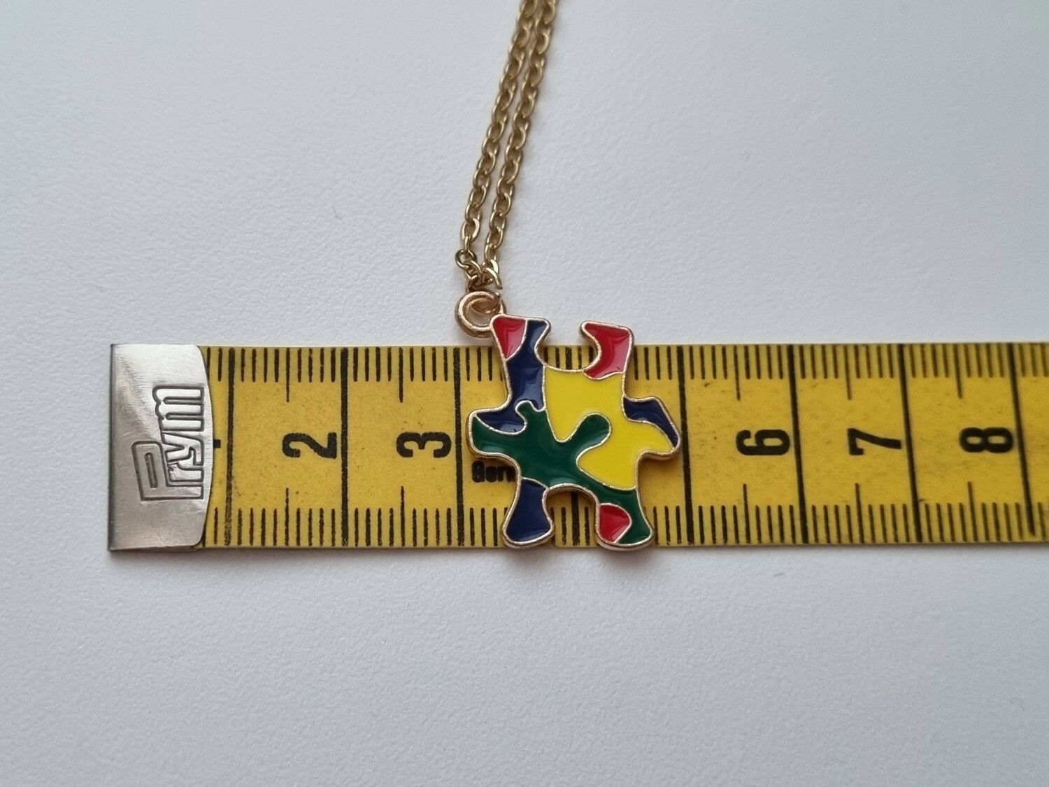 Guldfärgat halsband med en pusselbit / medvetenhet
