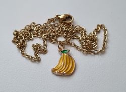 Guldfärgat halsband med en klase bananer