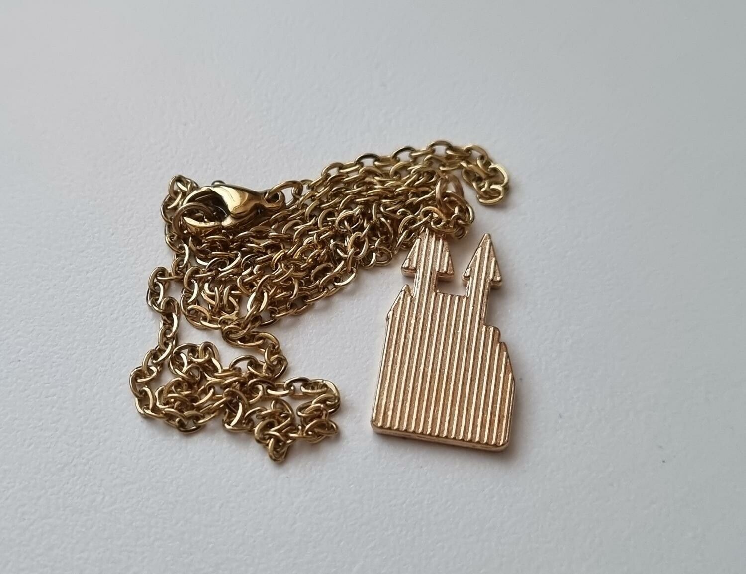 Guldfärgat halsband med ett slott