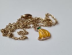 Guldfärgat halsband med en klase bananer
