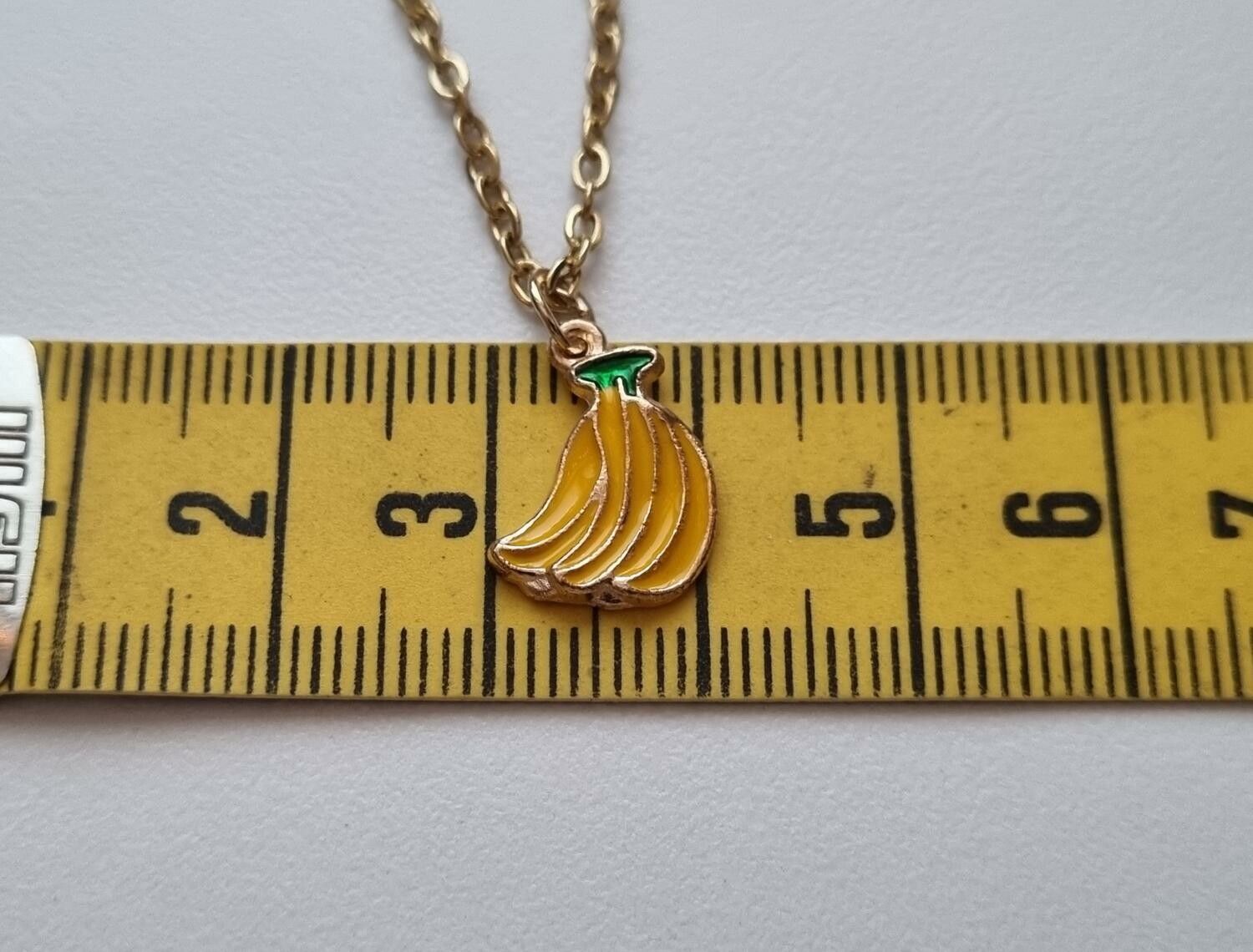 Guldfärgat halsband med en klase bananer