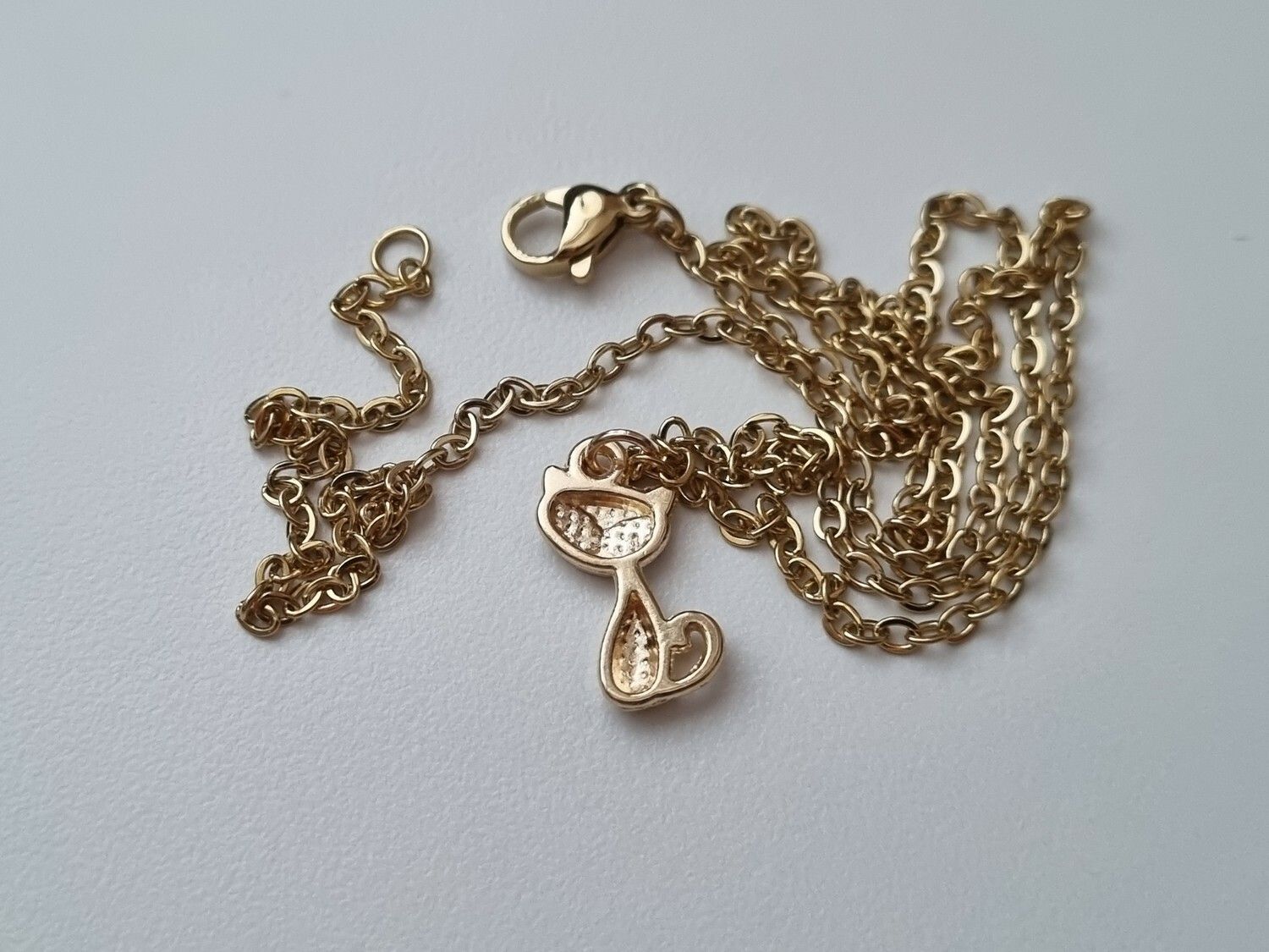 Guldfärgat halsband med en katt