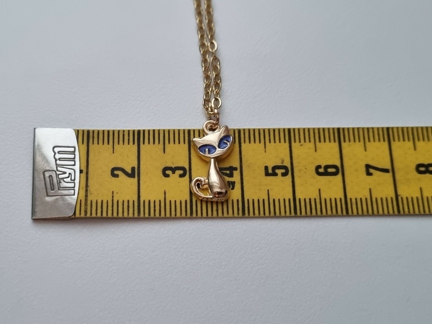 Guldfärgat halsband med en katt