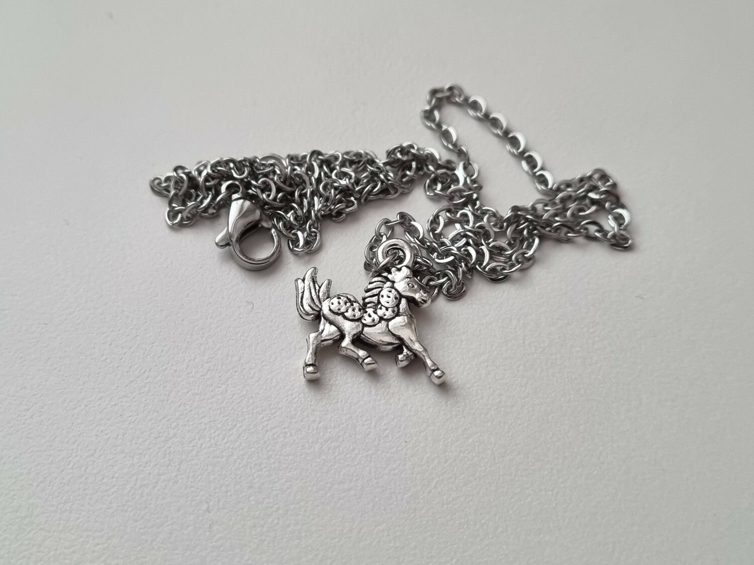 Silverfärgat halsband med en häst