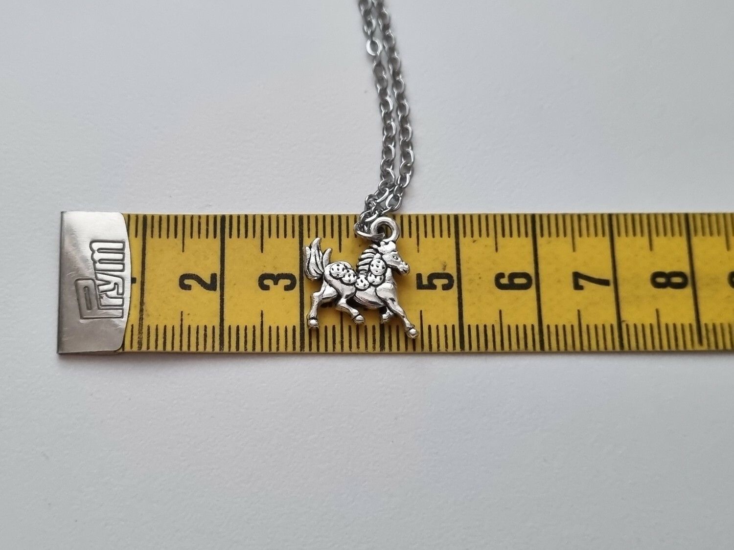 Silverfärgat halsband med en häst