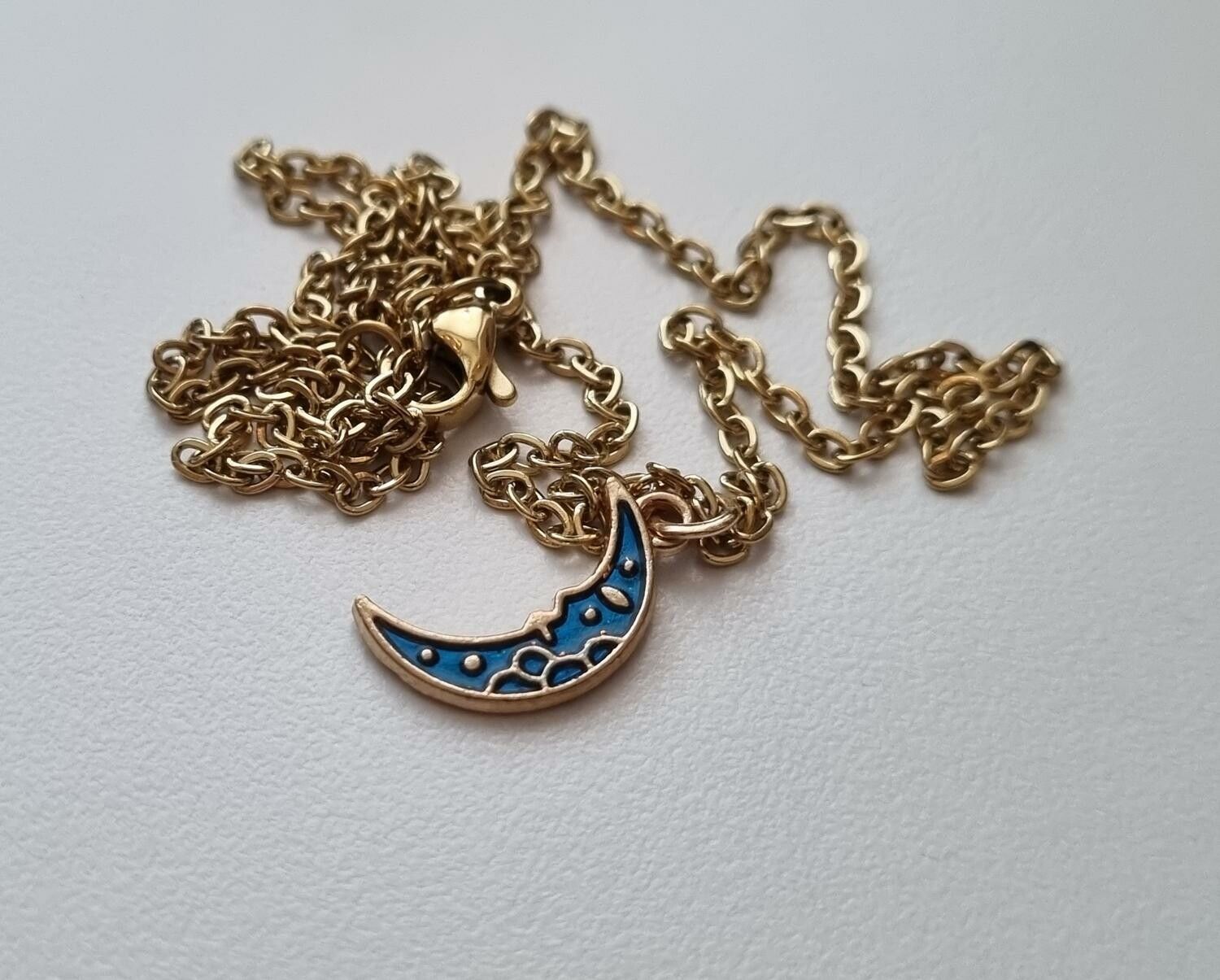 Guldfärgat halsband med en halv måne / halvmåne