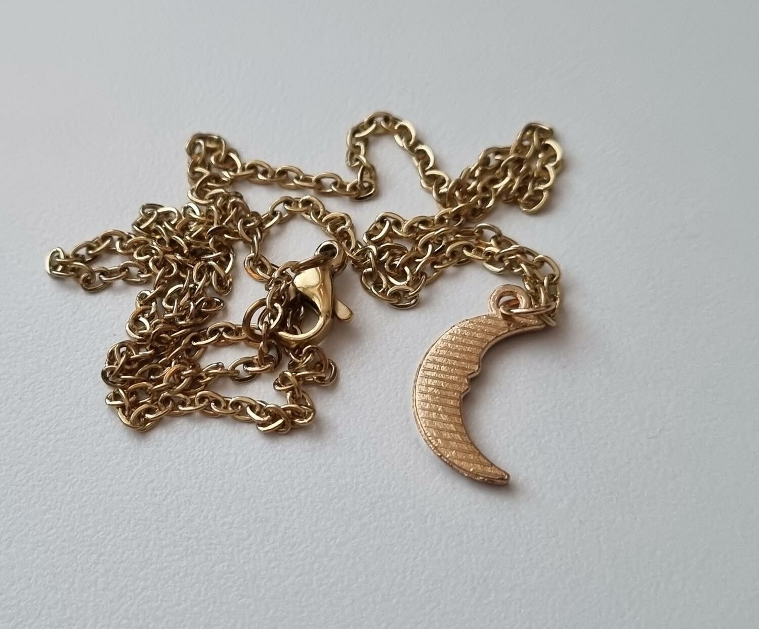 Guldfärgat halsband med en halv måne / halvmåne