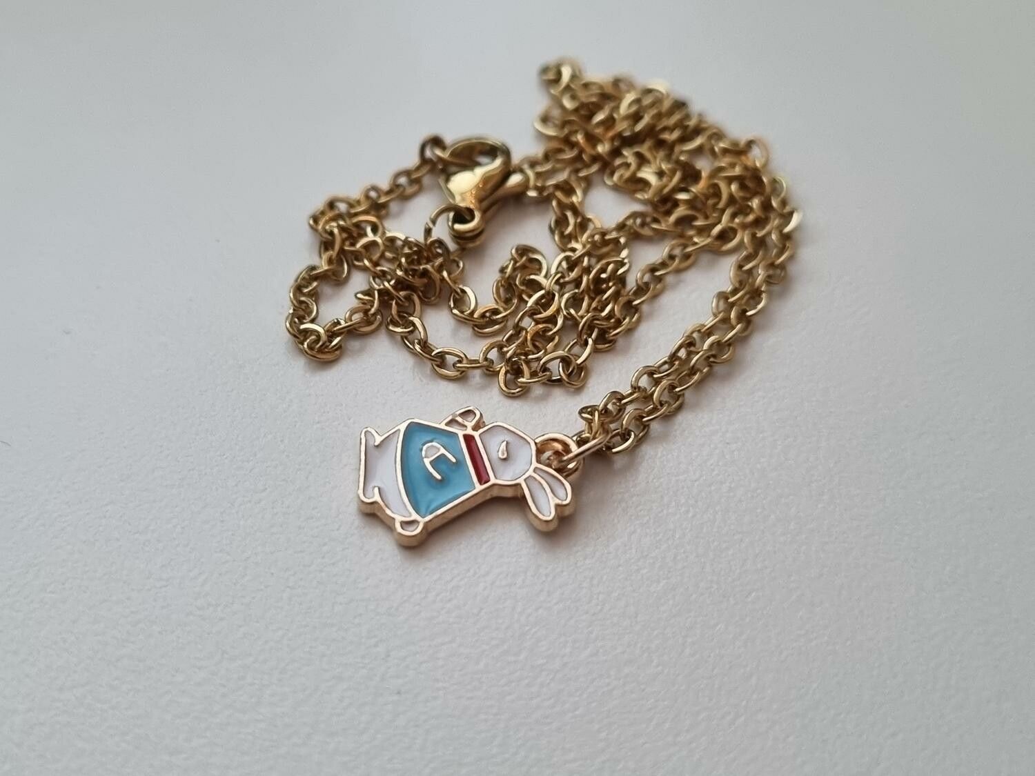 Guldfärgat halsband med en flerfärgad kanin / kaninberlock