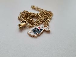 Guldfärgat halsband med en finklädd kanin i kostym