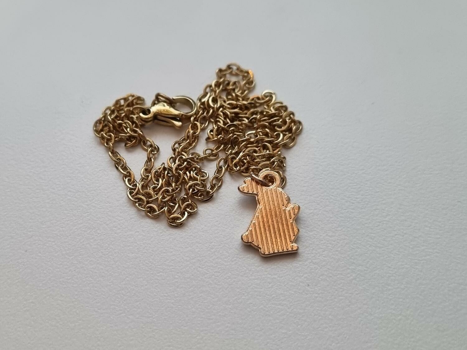 Guldfärgat halsband med en flerfärgad kanin / kaninberlock