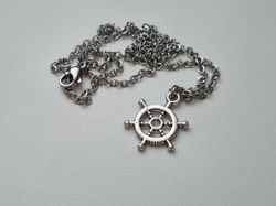 Silverfärgat halsband med en fartygsratt