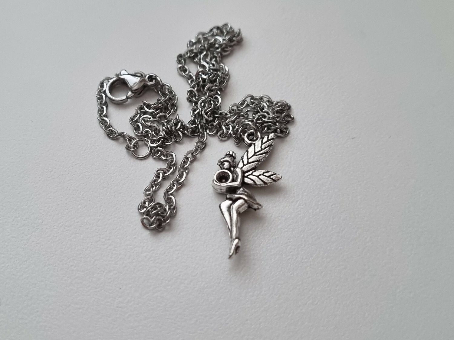 Silverfärgat halsband med en fe