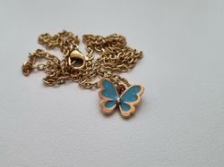 Guldfärgat halsband med en blå fjäril / fjärilsberlock