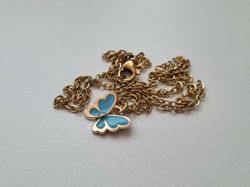 Guldfärgat halsband med en blå fjäril / fjärilsberlock