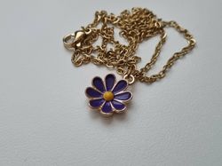 Guldfärgat halsband med en blomma