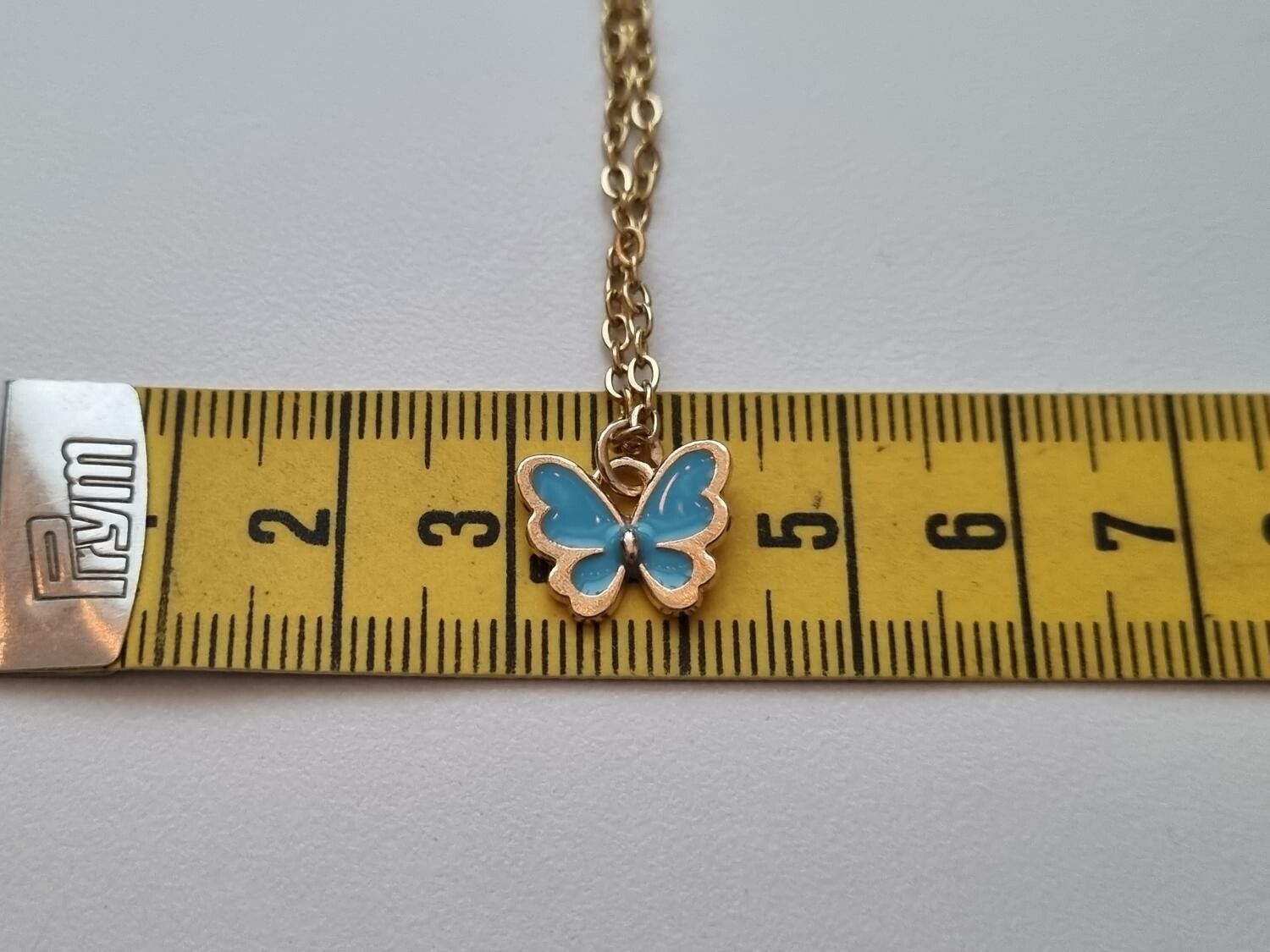Guldfärgat halsband med en blå fjäril / fjärilsberlock