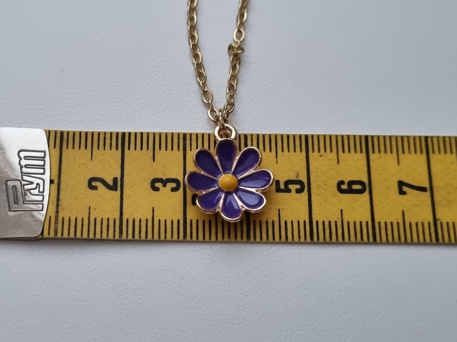 Guldfärgat halsband med en blomma