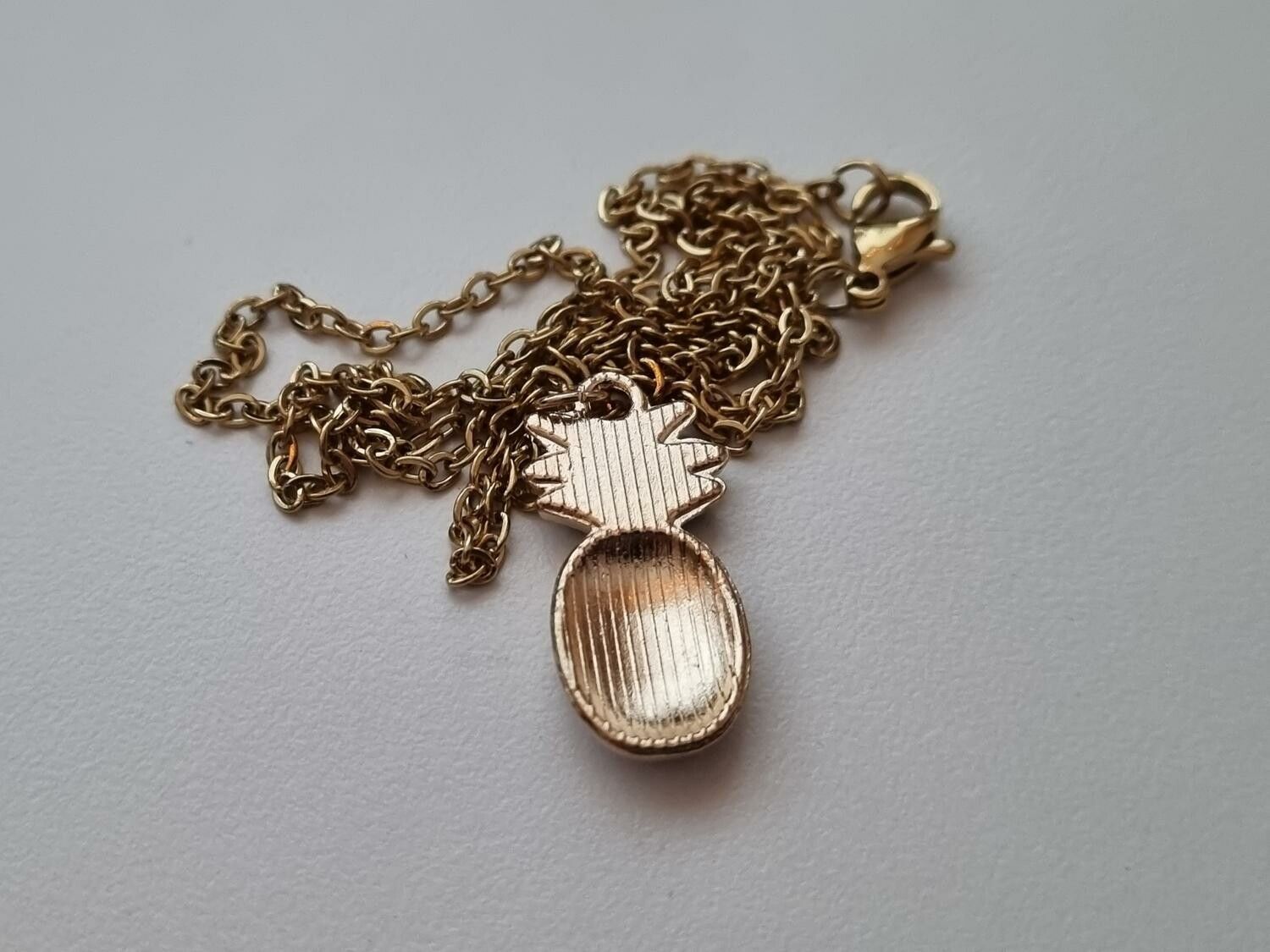 Guldfärgat halsband med en ananas / ananasberlock