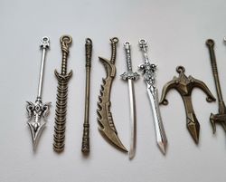 9 st berlocker - Miniatyrvapen, minisvärd, treuddar med mera