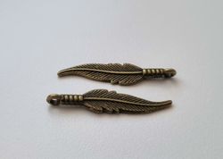 2 st bronsfärgade fjädrar / berlocker / hängen