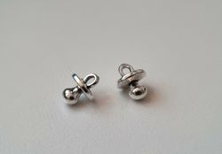 2 st silverfärgade nappar. Berlocker / charms