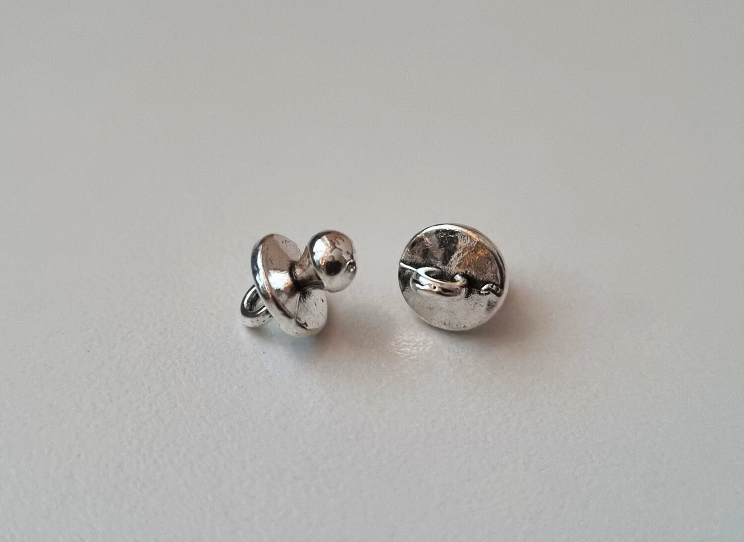 2 st silverfärgade nappar. Berlocker / charms