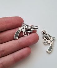 2 st silverfärgade revolvrar / pistoler. Hängen / berlocker