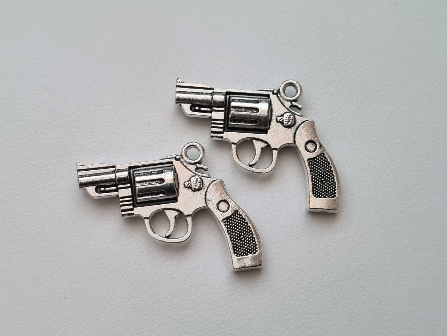 2 st silverfärgade revolvrar / pistoler. Hängen / berlocker