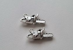 2 st silverfärgade motorsågar, hängen / berlocker