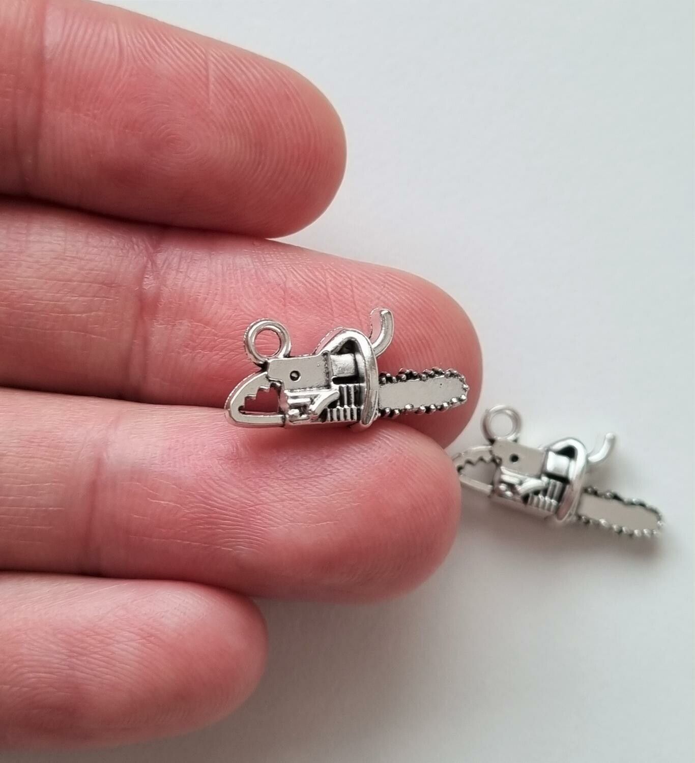 2 st silverfärgade motorsågar, hängen / berlocker
