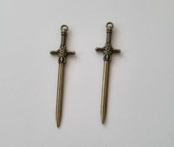 2 st bronsfärgade svärd. Berlocker / hänge / charm