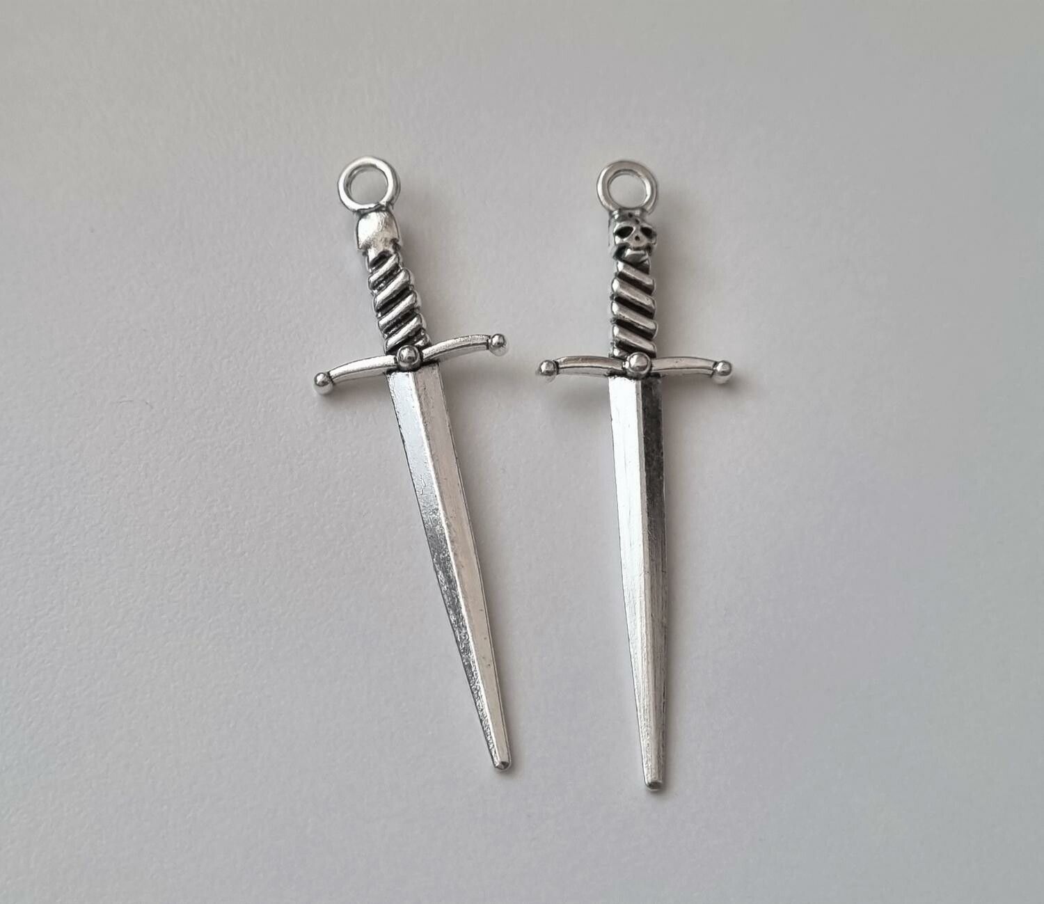 2 st silverfärgade svärd med dödskalle. Berlocker / hänge / charm