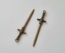 2 st bronsfärgade svärd. Berlocker / hänge / charm