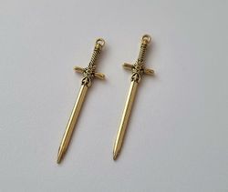 2 st guldfärgade svärd. Berlocker / hänge / charm