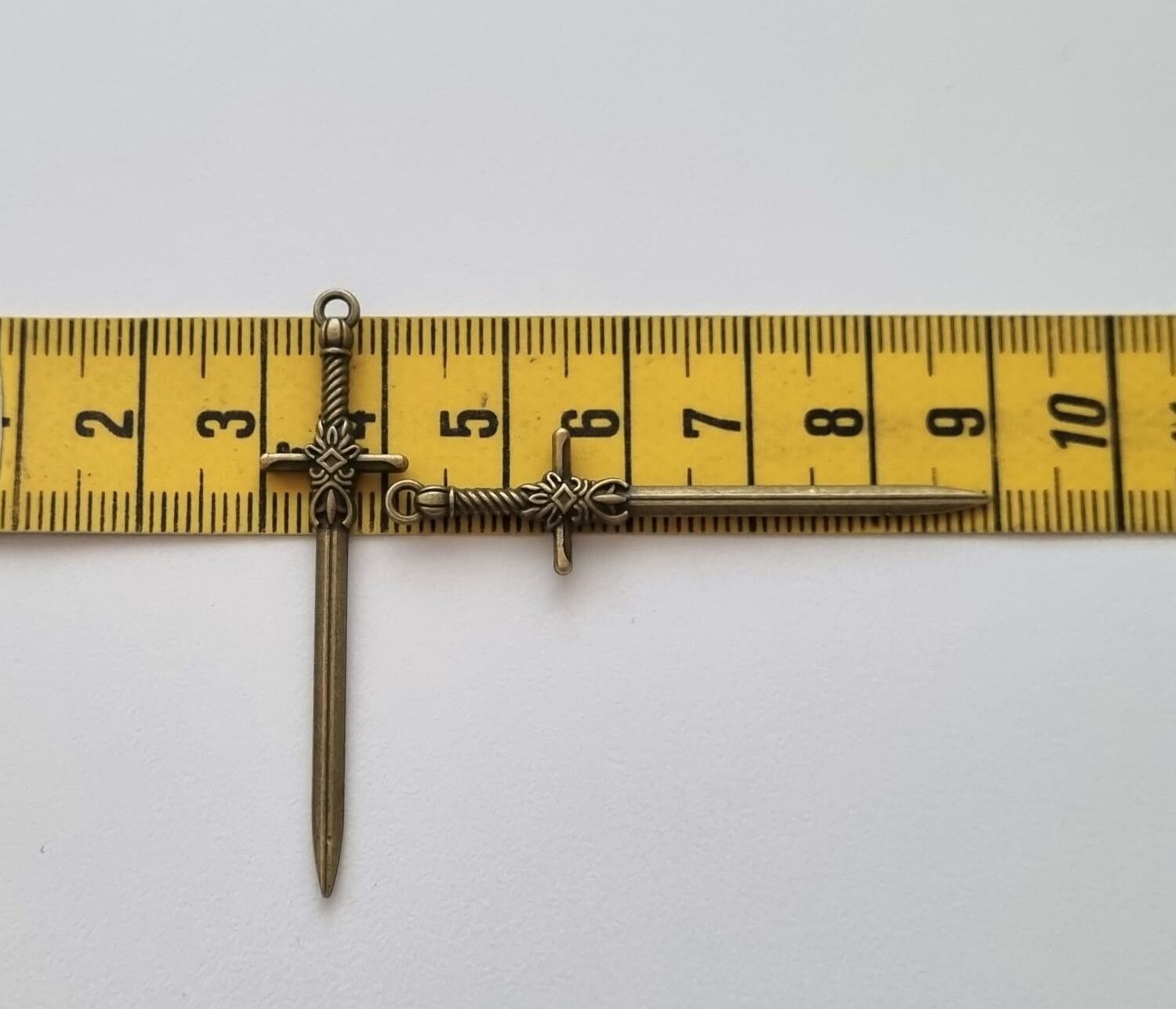 2 st bronsfärgade svärd. Berlocker / hänge / charm