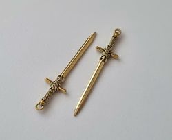 2 st guldfärgade svärd. Berlocker / hänge / charm