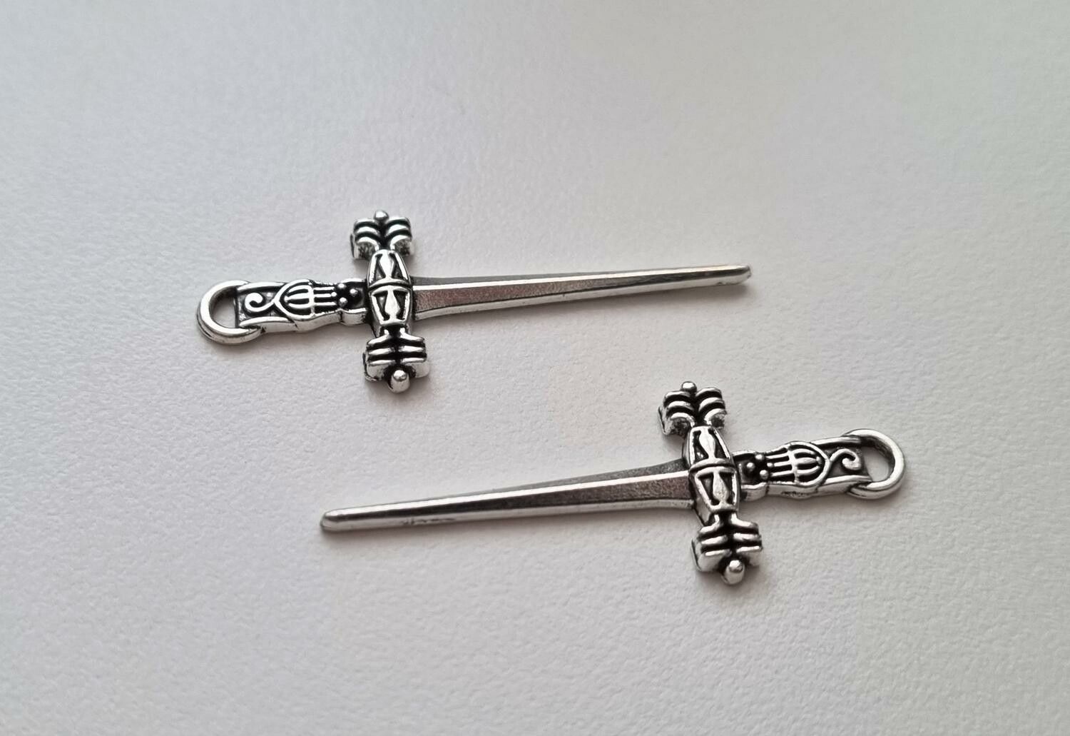 2 st silverfärgade svärd. Berlocker / hänge / charm