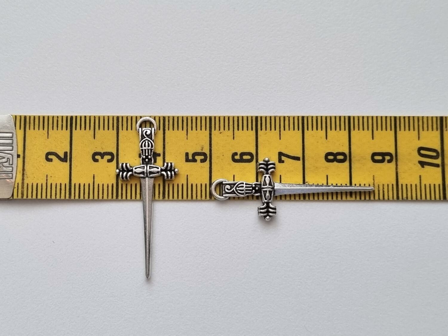 2 st silverfärgade svärd. Berlocker / hänge / charm