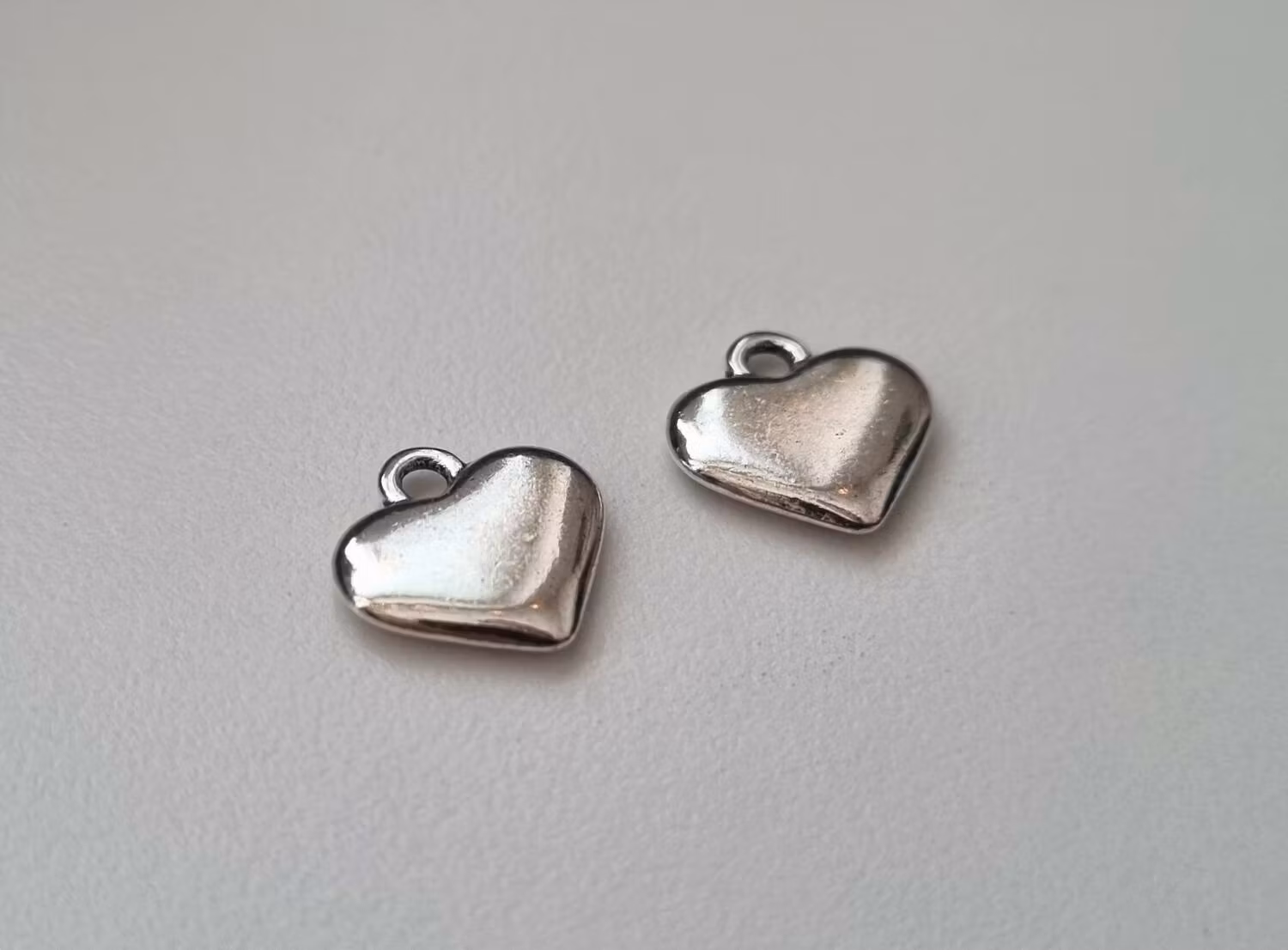 2 st silverfärgade hjärtan. Berlocker / hänge / charm