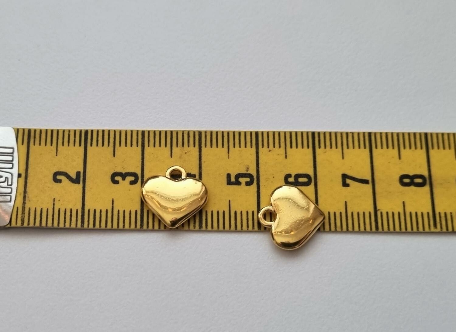 2 st guldfärgade hjärtan. Berlocker / hänge / charm